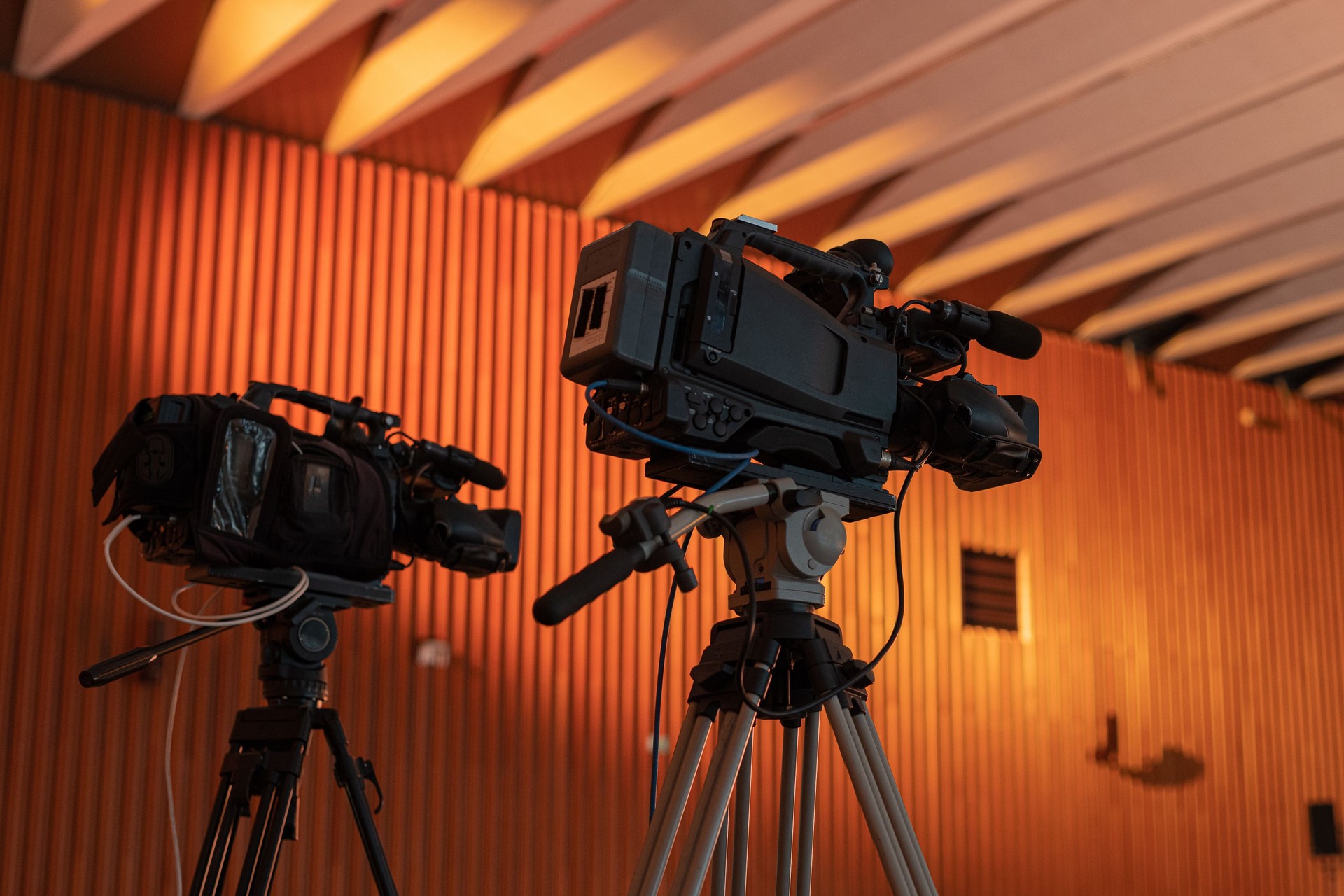 Two video cameras for a live stream or video production at a fancy gala event. Two cameras on tripods at an event.